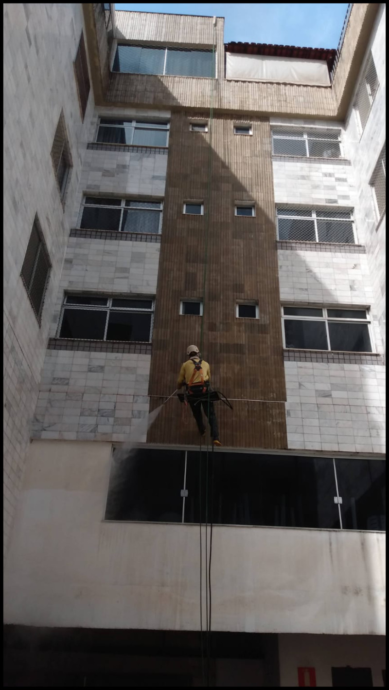 Profissional da Vertical Chão executando serviço em fachada de edifício