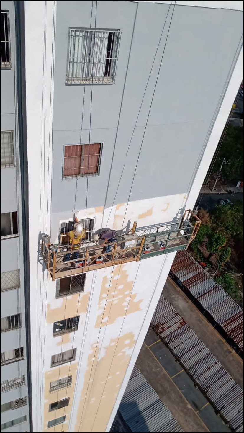 Profissional em serviço de manutenção predial por corda